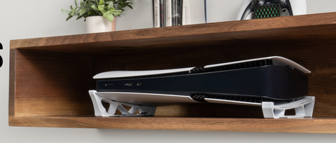 White Skates supporting a PlayStation 5 on a wooden shelf